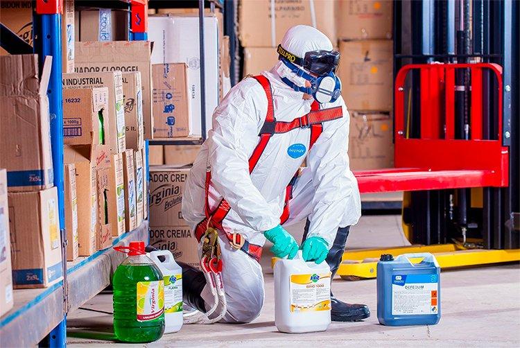 Safety suit man moving toxic chemicals 