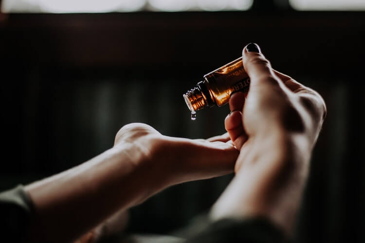 woman pouring oil on her hands