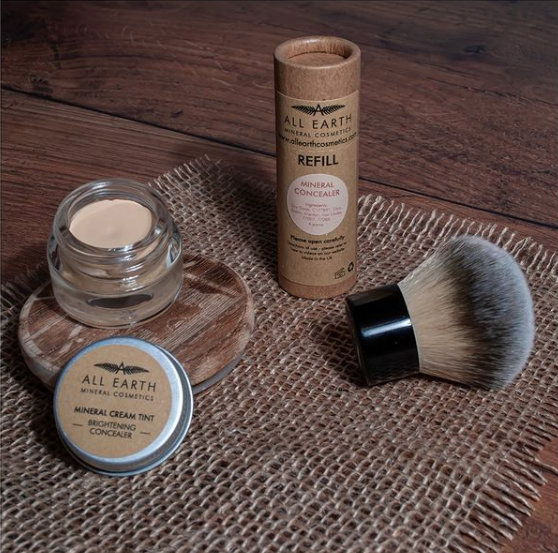 All Earth Mineral Cosmetics' mineral cream tint, concealer and brush on a rustic brown background.