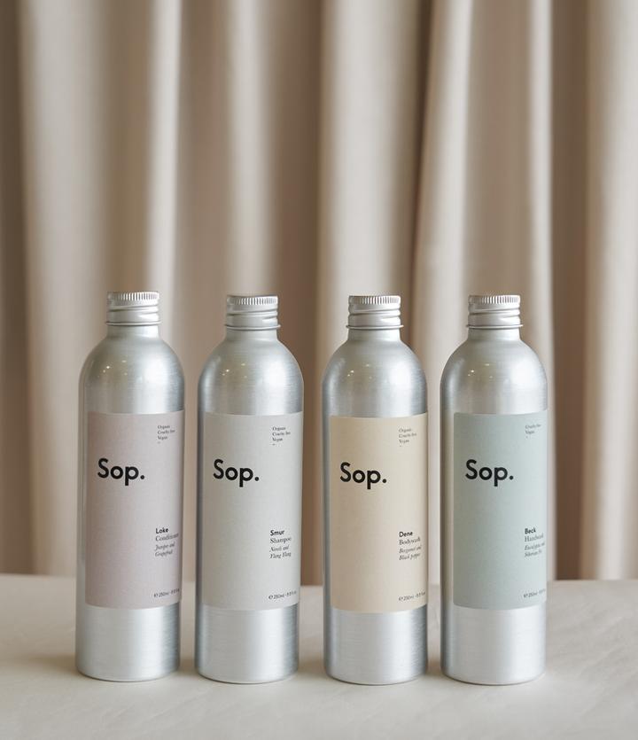 Sop shampoo, conditioner and body wash against a natural beige background
